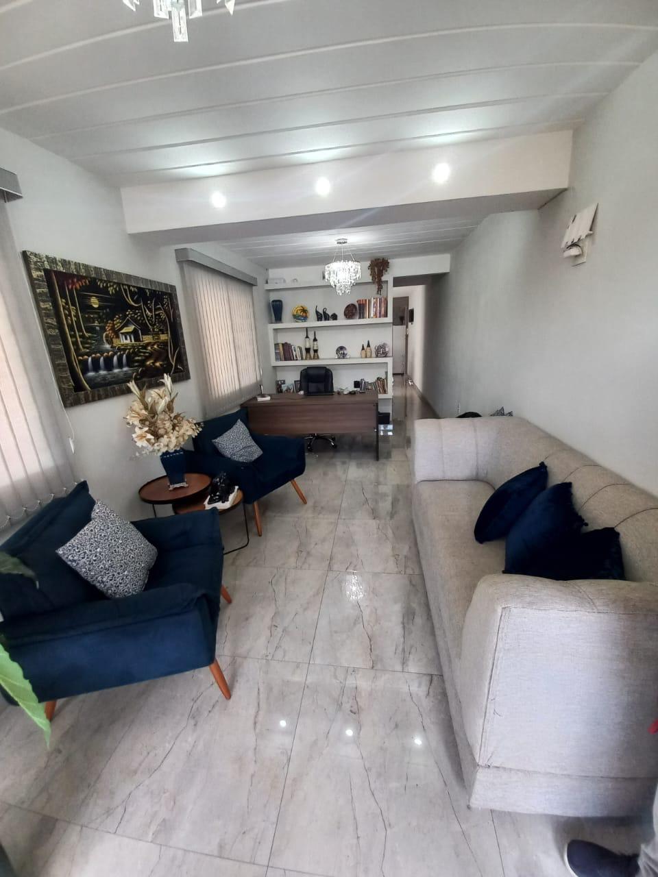 Sala de estar com sofás, poltronas e luz natural